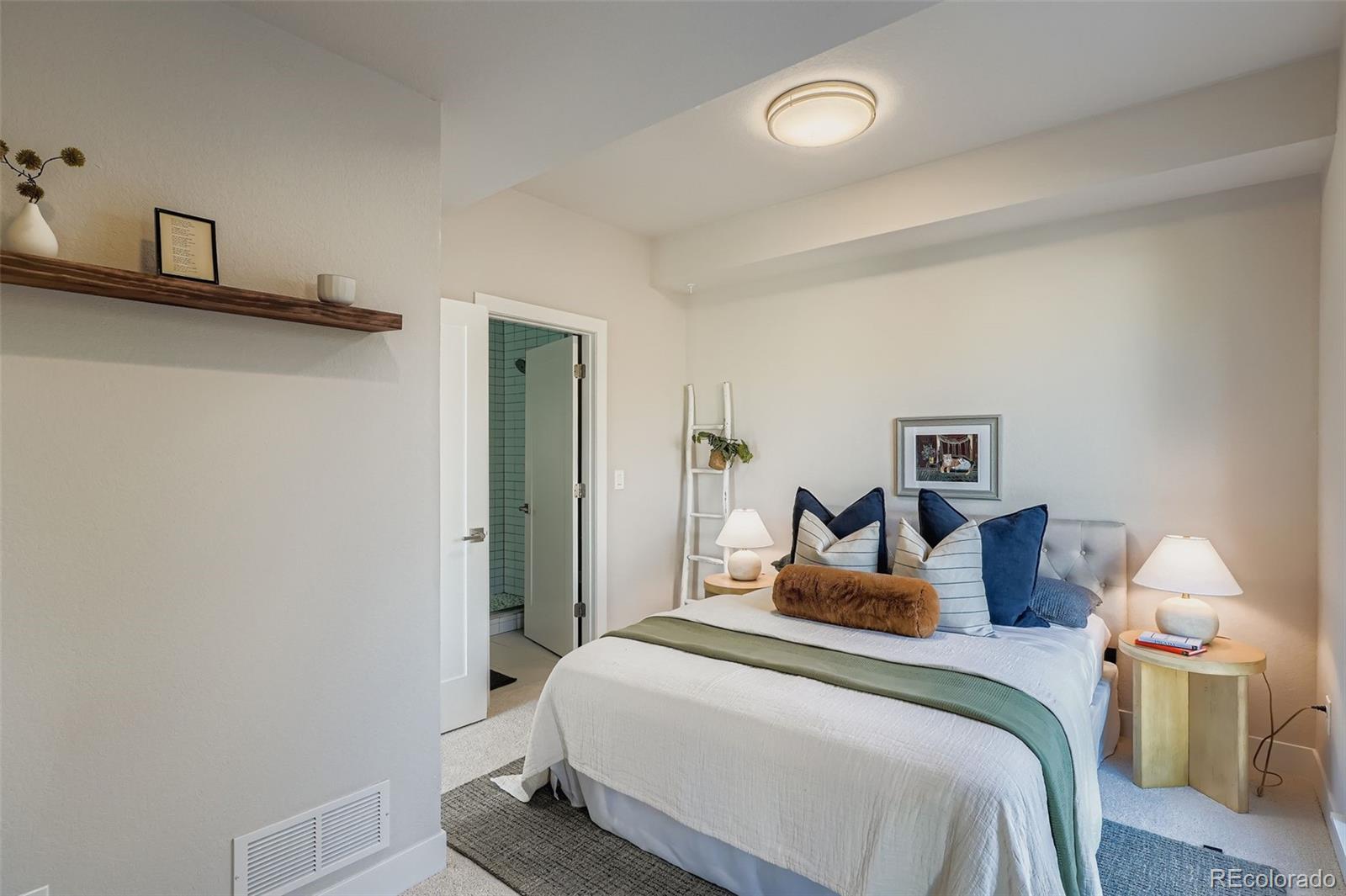 1261 Xavier Street Denver, CO 80204 - Photo 10 of 27 a bedroom with a bed and a lamp on table