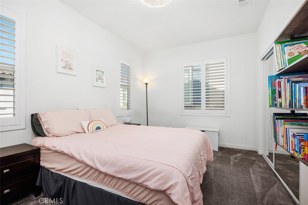 4130 Via Del Rey Oceanside, CA 92057 - Photo 20 of 35 a bedroom with a bed a dresser and a book shelf