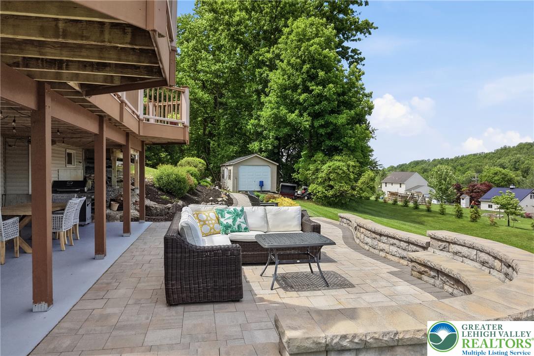 115 West Butternut Road Hellertown, PA 18055 - Photo 73 of 97 An inviting stone patio and lower deck provide ample outdoor living space amidst lush green landscaping.