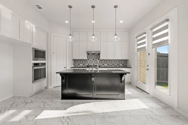 a kitchen with stainless steel appliances kitchen island granite countertop a stove a sink and a refrigerator