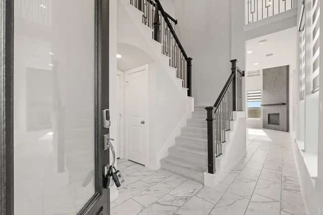 a view of a hallway with staircase and white walls