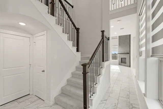 a view of staircase with lots of frames on wall and a dining table