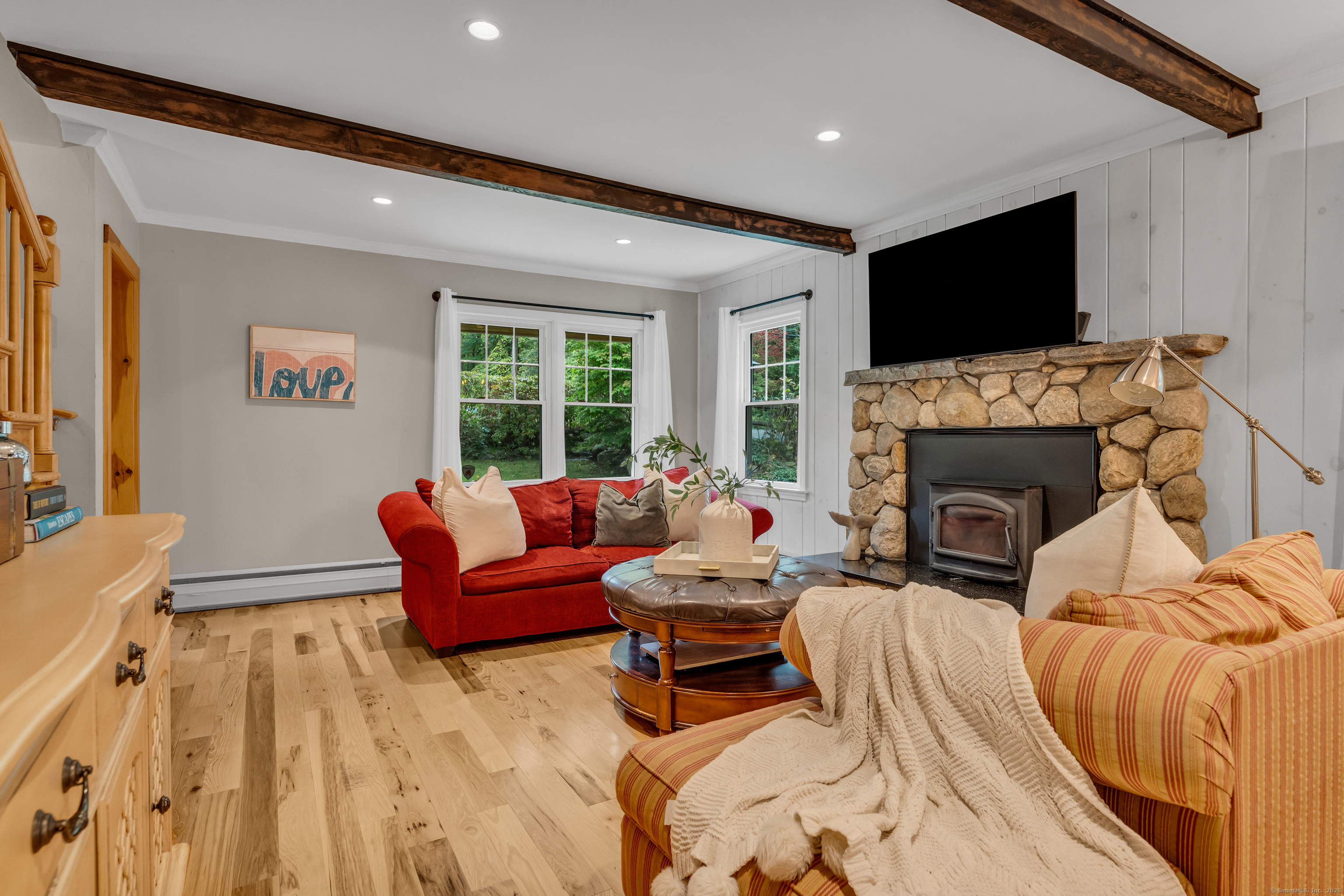 735 Opening Hill Road Madison, CT 06443 - Photo 11 of 39 a living room with furniture a flat screen tv and a fireplace