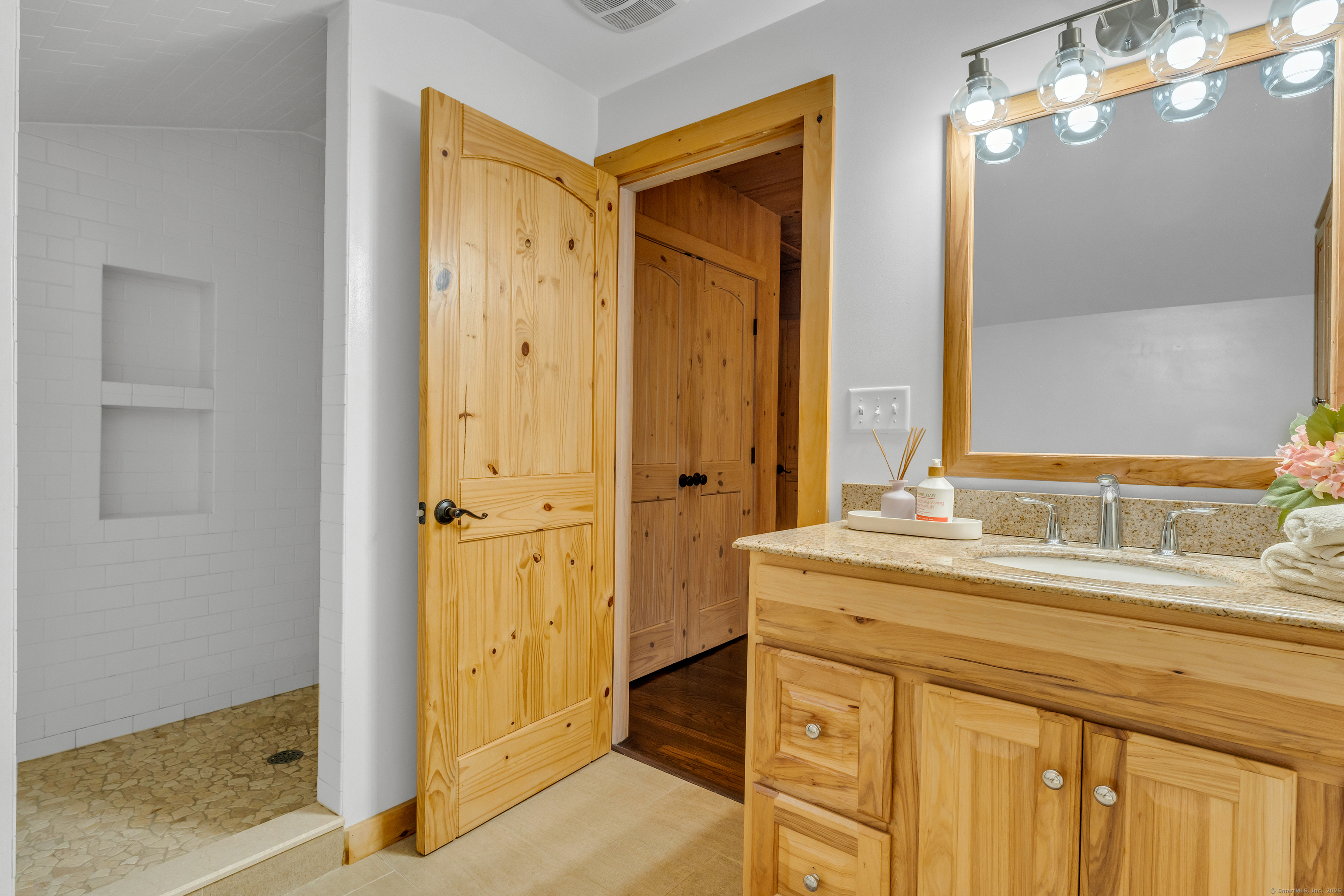 735 Opening Hill Road Madison, CT 06443 - Photo 23 of 39 a bathroom with a granite countertop sink a mirror and a shower