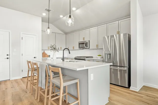 a kitchen with kitchen island a sink stove and refrigerator