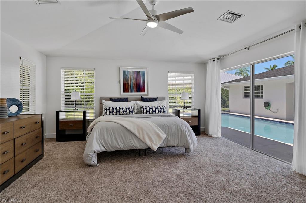 740 Orchid Drive Naples, FL 34102 - Photo 16 of 33 a spacious bedroom with a bed and a window