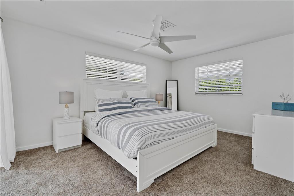 740 Orchid Drive Naples, FL 34102 - Photo 25 of 33 a bedroom with a bed and a table