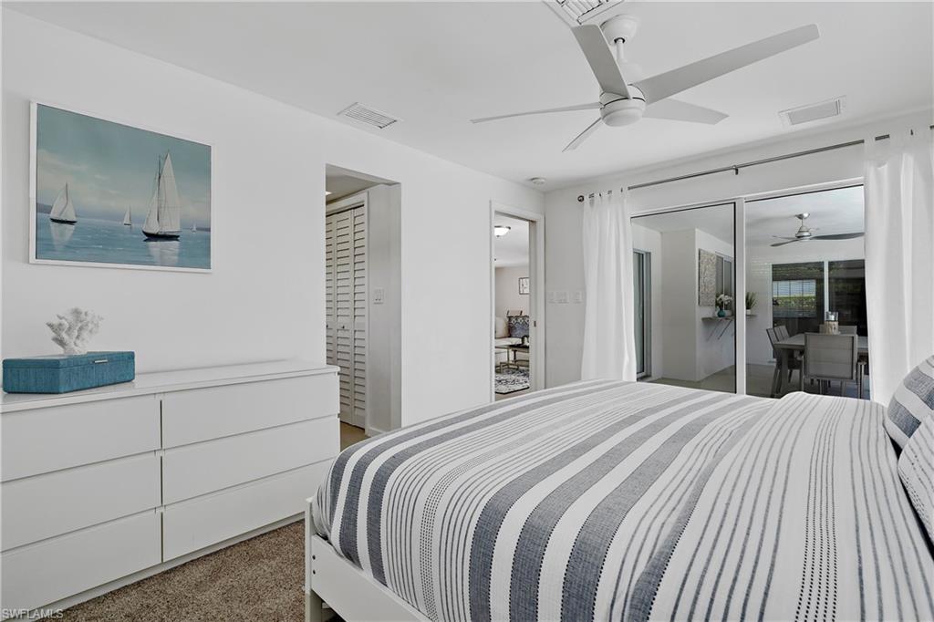 740 Orchid Drive Naples, FL 34102 - Photo 26 of 33 a bedroom with a large bed and a chandelier