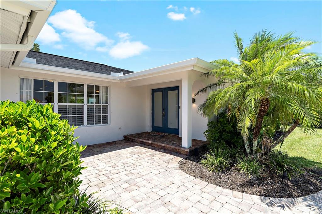 740 Orchid Drive Naples, FL 34102 - Photo 32 of 33 a front view of a house with a yard and potted plants