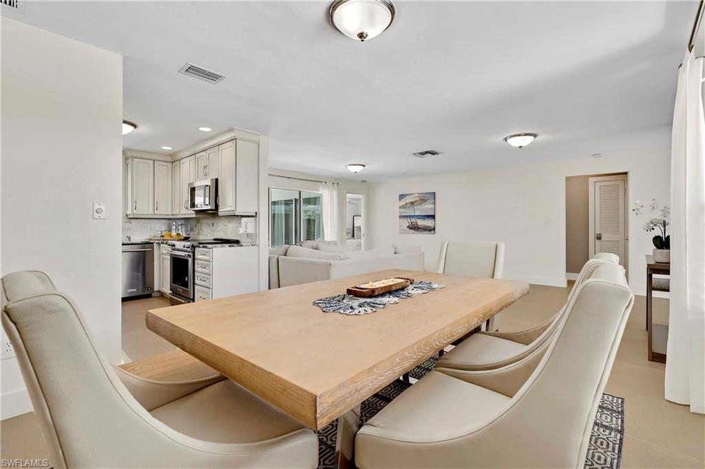 740 Orchid Drive Naples, FL 34102 - Photo 8 of 33 a kitchen with a dining table chairs and refrigerator
