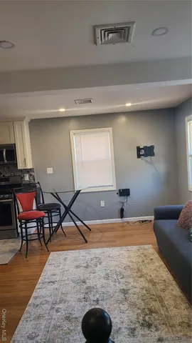 a living room with dining room and wooden floor