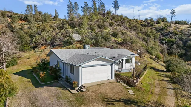 a view of a house with a yard and sitting area