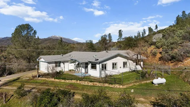 a aerial view of a house with a big yard and large trees