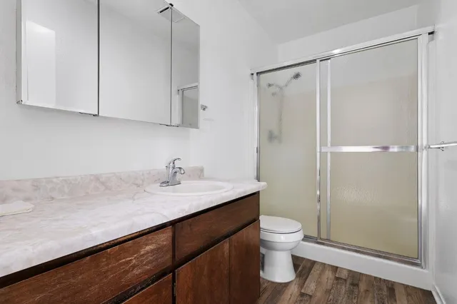 a bathroom with a sink a toilet and shower