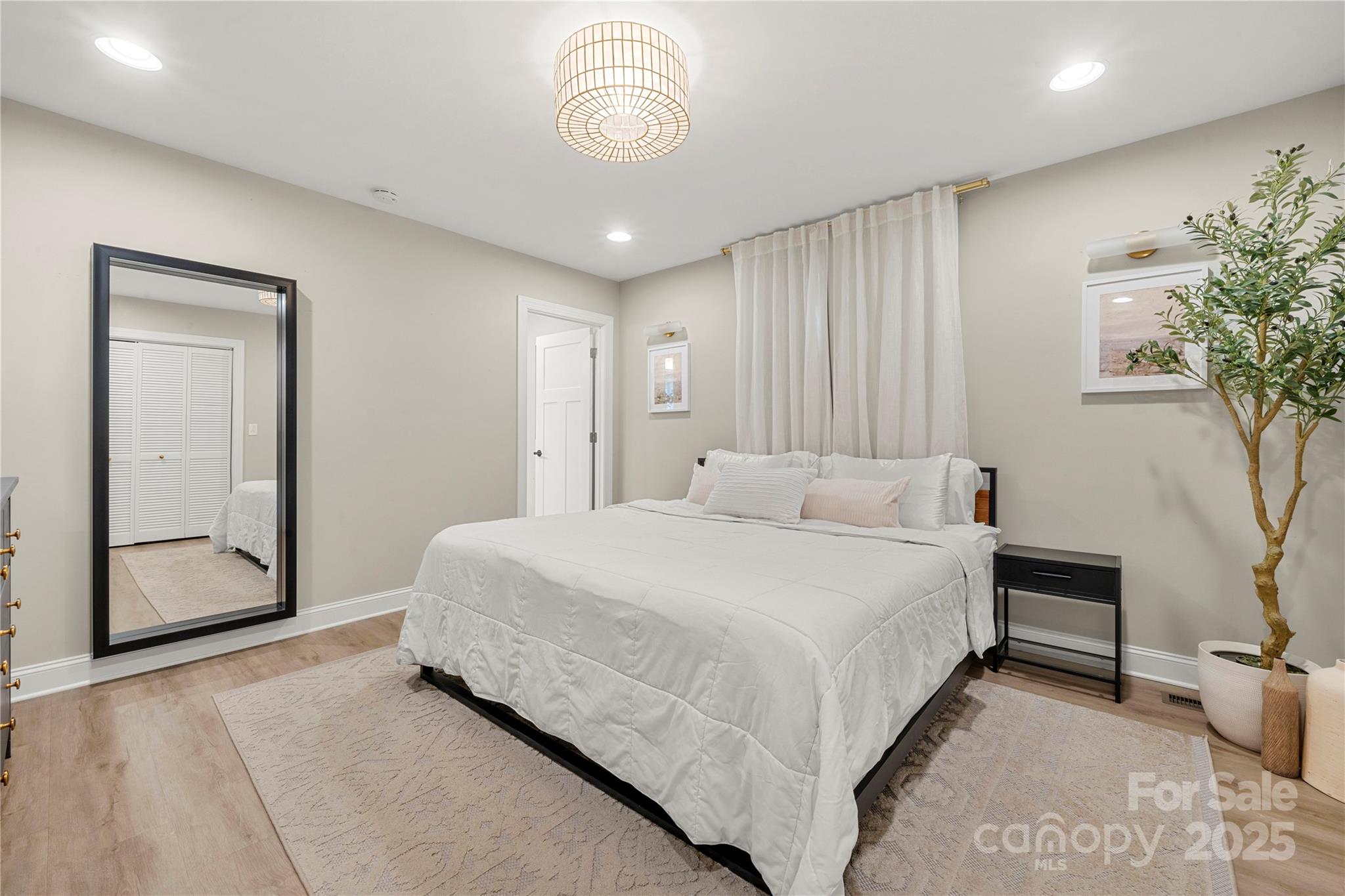 4820 Valley Stream Road Charlotte, NC 28209 - Photo 19 of 37 a spacious bedroom with a bed and a potted plant