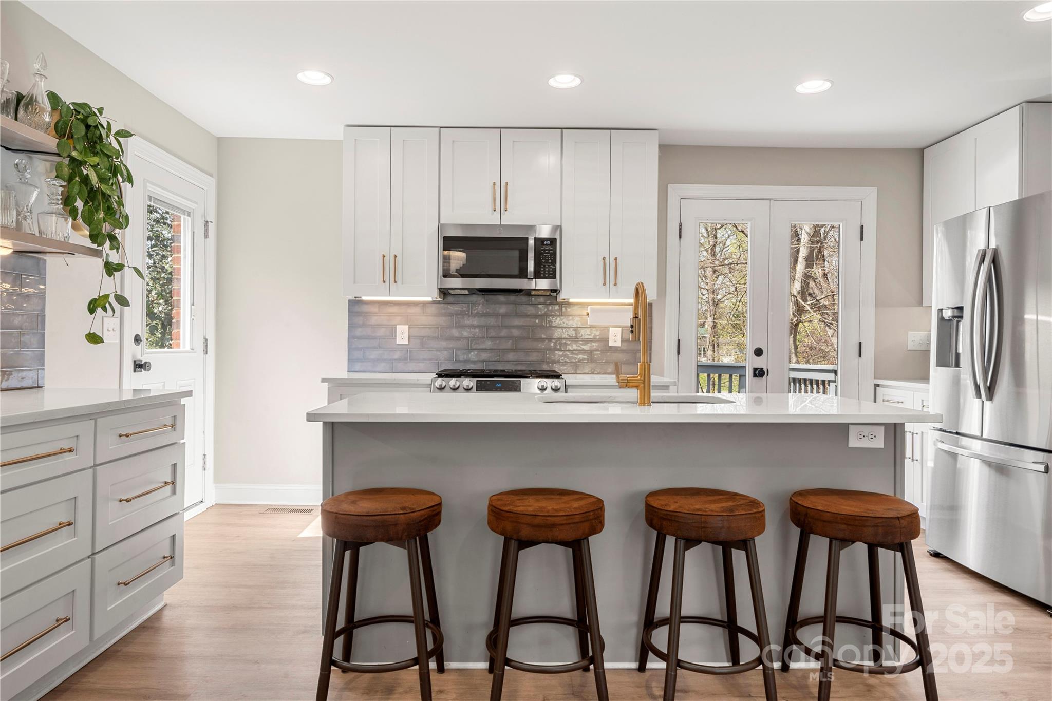 4820 Valley Stream Road Charlotte, NC 28209 - Photo 9 of 37 a kitchen with stainless steel appliances a dining table chairs refrigerator and microwave