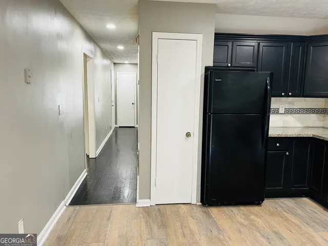 a kitchen with kitchen island granite countertop wooden cabinets and refrigerator