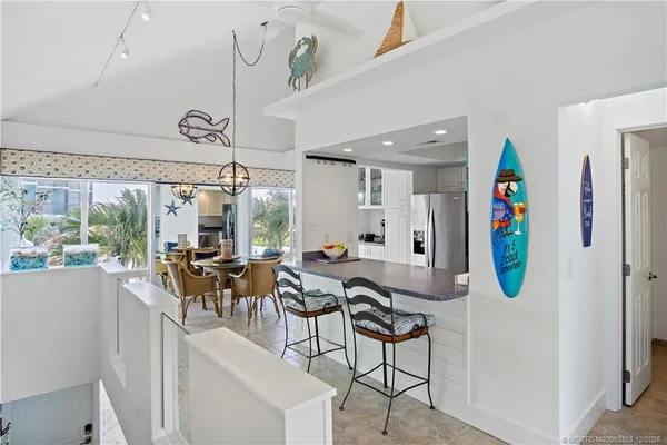 a view of a dining room and livingroom with furniture wooden floor a chandelier
