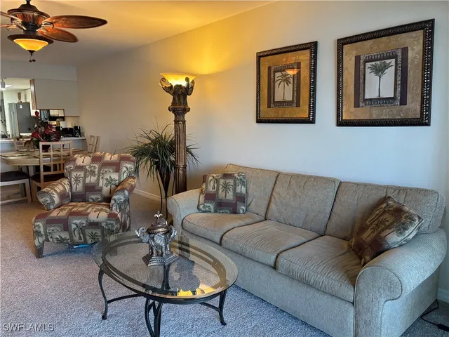 a living room with furniture a rug and a chandelier