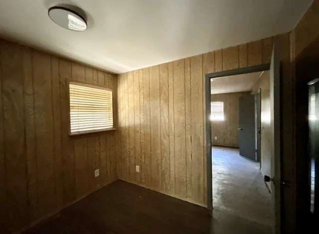 an empty room with wooden floor and a window