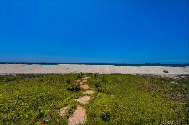 a view of a kitchen with stainless steel appliances kitchen island granite countertop a refrigerator and a stove top oven