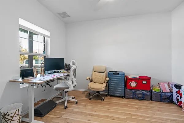 a view of a workspace with furniture and a window