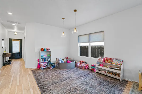 a playing room with furniture and wooden floor