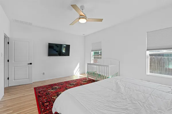 a bedroom with a large bed a flat tv screen and dresser