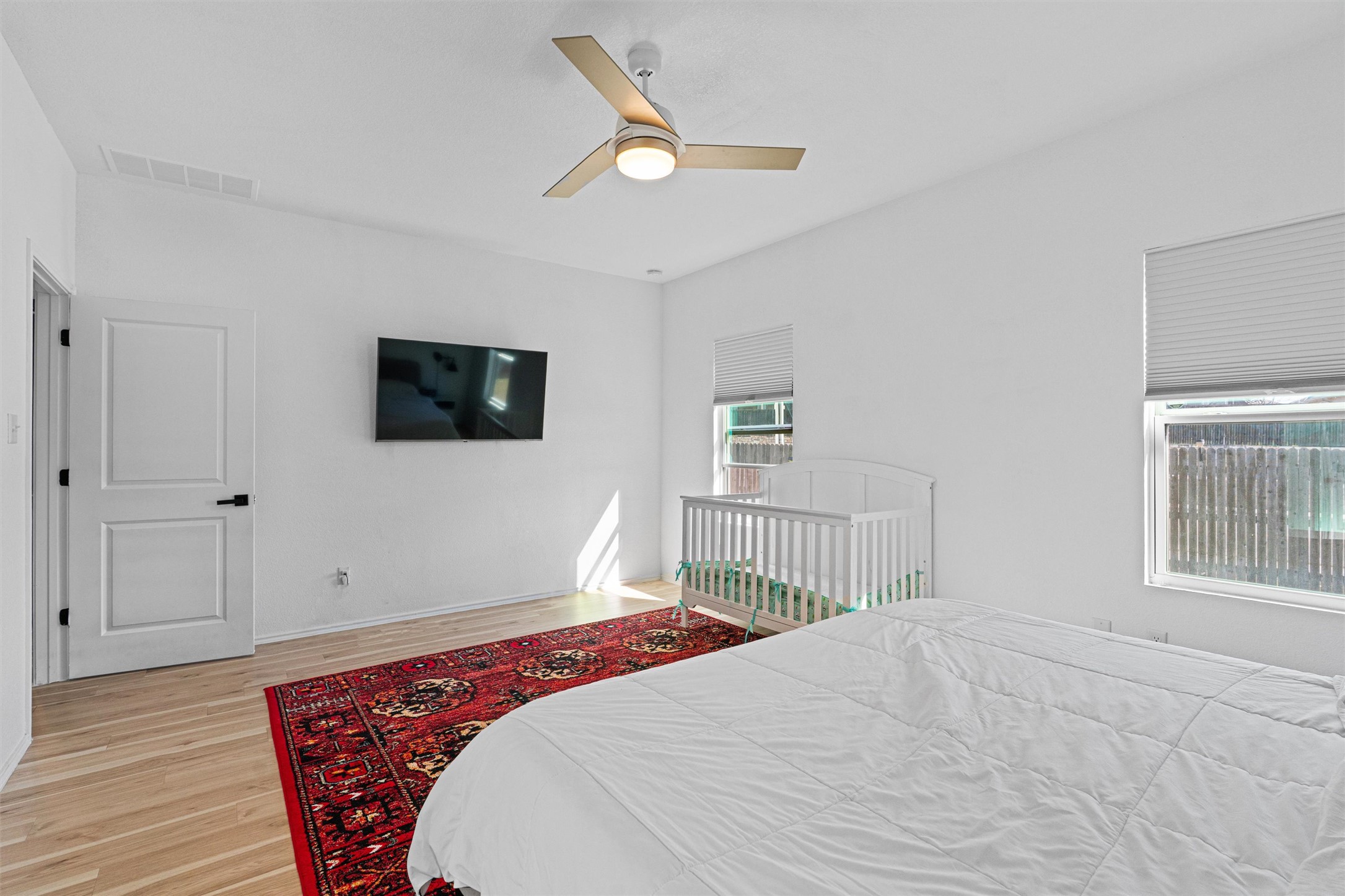 327 Andesite Trail Buda, TX 78610 - Photo 17 of 40 a bedroom with a large bed a flat tv screen and dresser