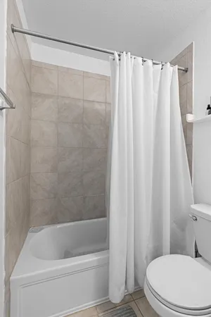 a white toilet sitting next to a bath tub