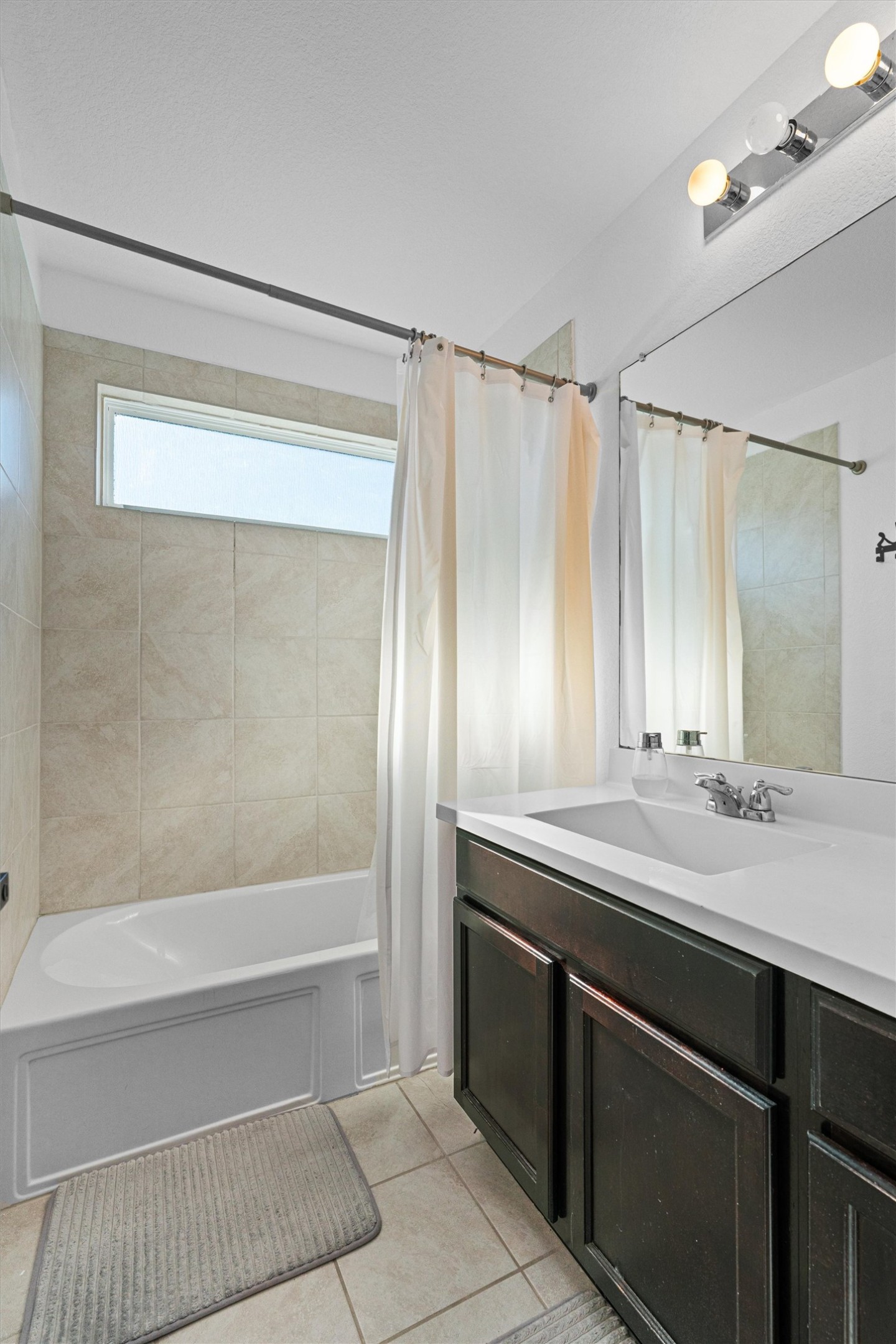 327 Andesite Trail Buda, TX 78610 - Photo 32 of 40 a bathroom with a sink a mirror and a bathtub