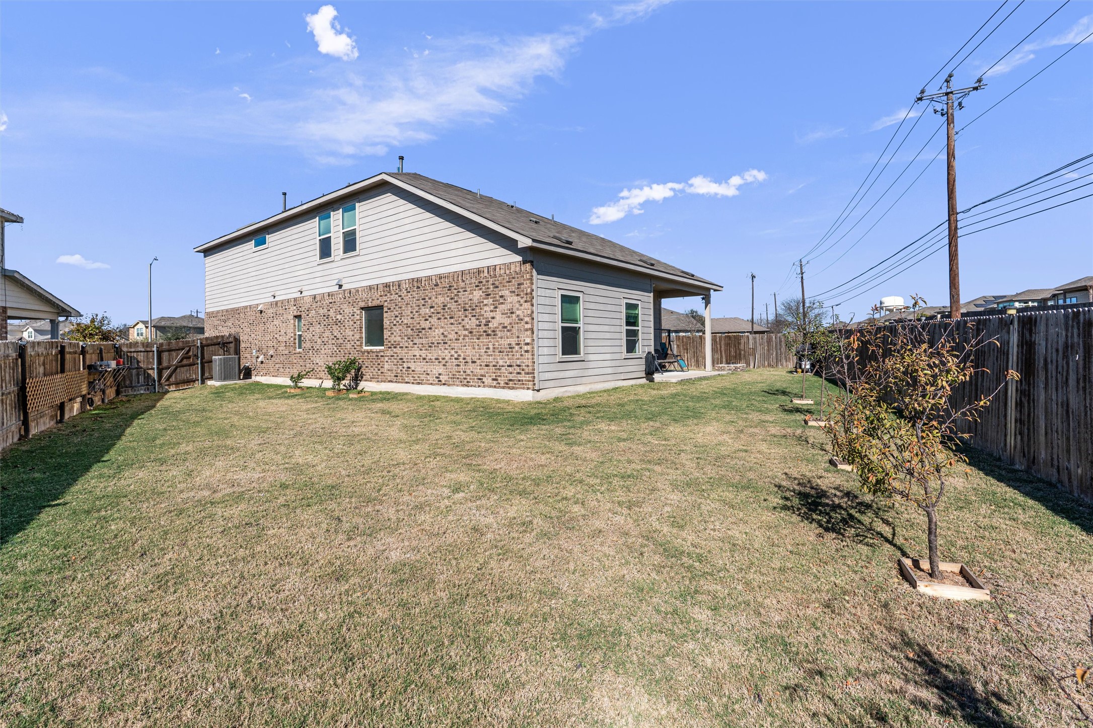 327 Andesite Trail Buda, TX 78610 - Photo 39 of 40 View of side of property featuring a fenced backyard, a patio, brick siding, and a gate