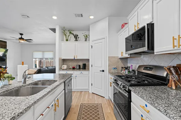 a kitchen with granite countertop a sink and a stove top oven