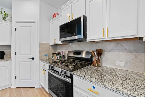 a kitchen with stainless steel appliances granite countertop a sink and a stove