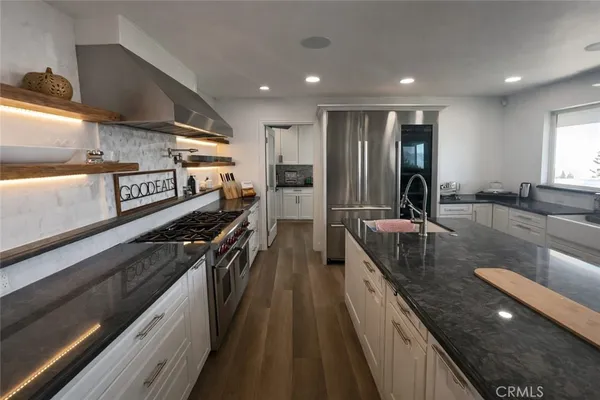a kitchen with granite countertop a refrigerator a sink and dishwasher