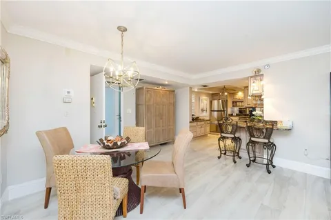 a dining room with furniture a chandelier and wooden floor