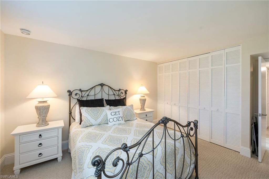 1200 Blue Point Avenue, Unit A2 Naples, FL 34102 - Photo 18 of 30 This room features light-colored walls, carpeted flooring, and white louvered bifold closet doors