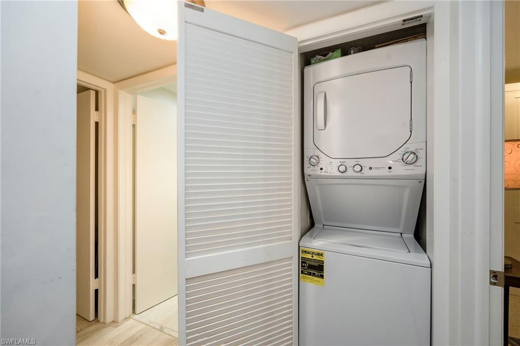 1200 Blue Point Avenue, Unit A2 Naples, FL 34102 - Photo 21 of 30 Dedicated laundry closet featuring a stacked washer and dryer unit with louvered bifold doors