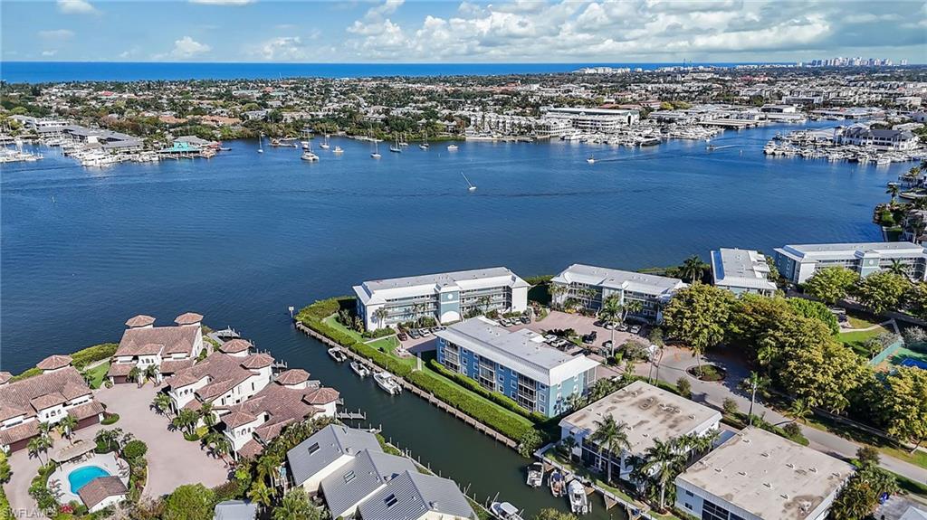 1200 Blue Point Avenue, Unit A2 Naples, FL 34102 - Photo 28 of 30 Aerial view showcasing the property's waterfront location, with canals, boat docks, and views of the wider waterway and coastline