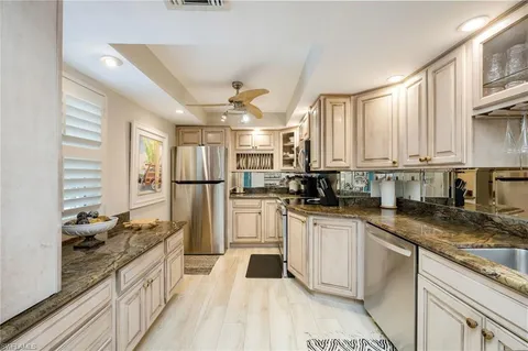 a kitchen with stainless steel appliances granite countertop a stove a sink and a refrigerator