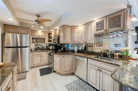 a kitchen with a sink stainless steel appliances and white cabinets