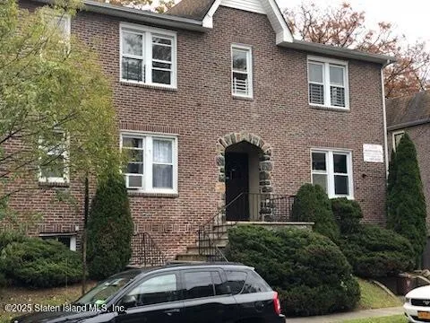 a car parked in front of a brick house