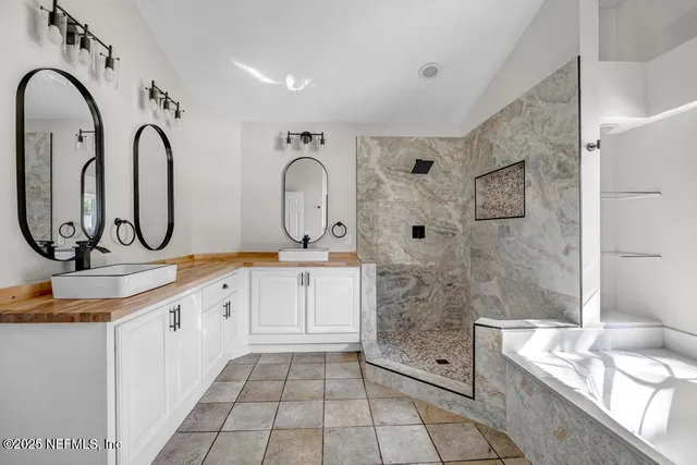a bathroom with a double vanity sink mirror and shower