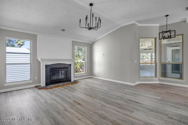 a view of empty room with wooden floor and fireplace
