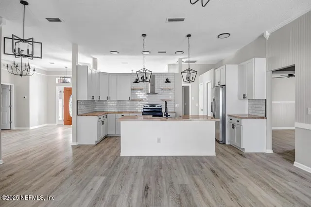 a large kitchen with cabinets wooden floor and stainless steel appliances