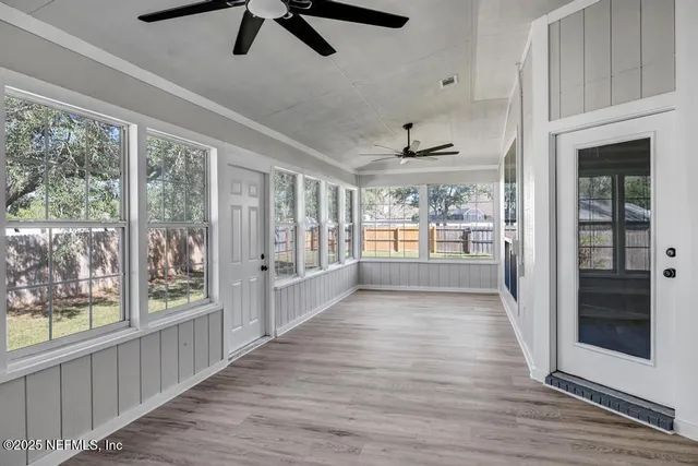 a view of hallway with wooden floor and windows