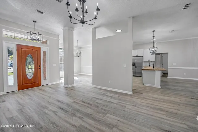 a view of a kitchen with a sink and wooden floor