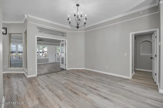 a view of a hallway with wooden floor and a chandelier