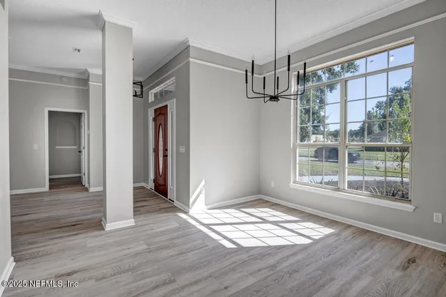 a view of empty room with wooden floor and window