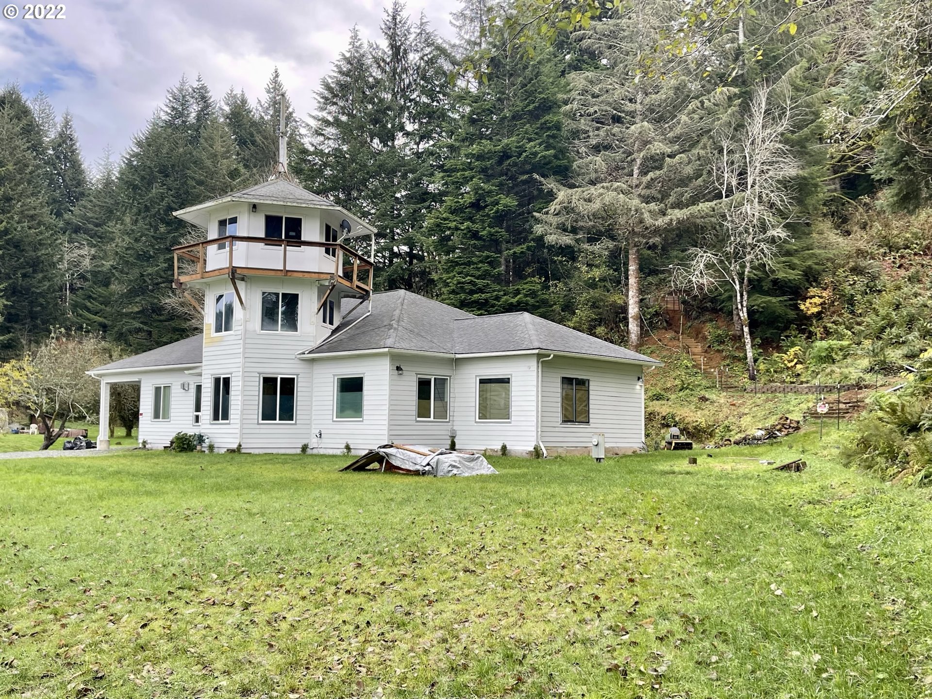 66325 North Bay Road North Bend, OR 97459 - Photo 1 of 31 a front view of a house with a garden and trees